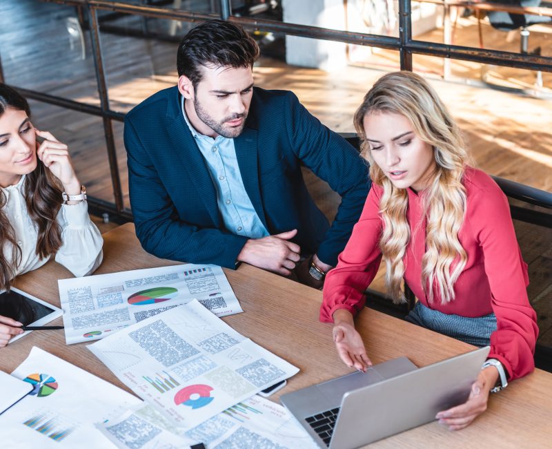 high angle view of business team working on new business idea together at workplace with papers in